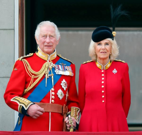 King Charles  smiling with Queen Camilla. 