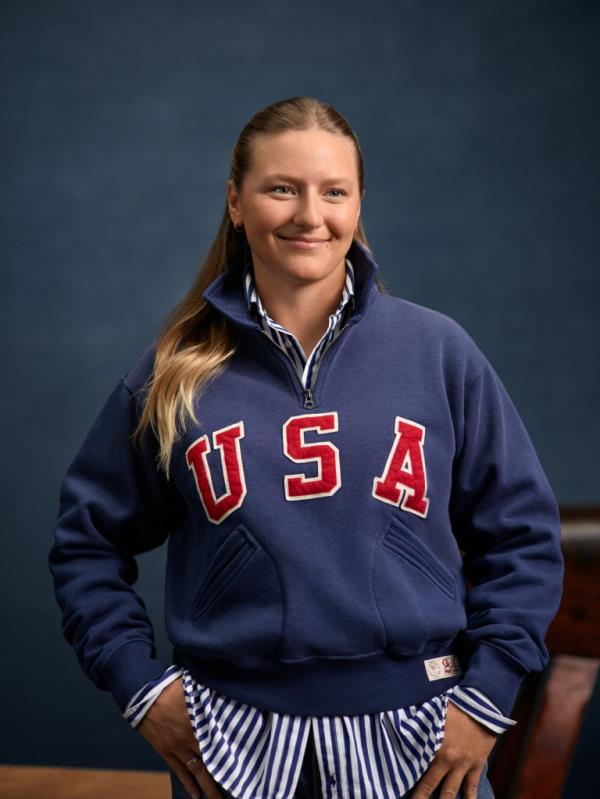 A woman smiling with her hands in her pockets at the Ralph Lauren Olympics photoshoot