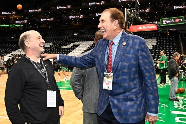 Jeff Van Gundy and Rudy Tomjanovich embracing on a basketball court before the Dallas Mavericks and Boston Celtics game during the 2024 NBA Finals