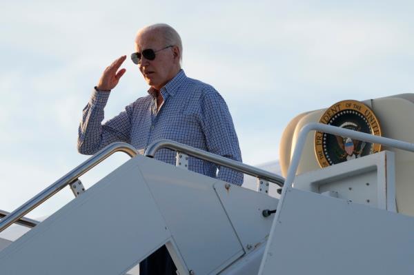 President Joe Biden salutes as he boards <a href=